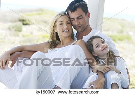 Parents and daughter smiling for the camera, outdoors View Large Photo Image Stock Photo - Parents and daughter smiling for the camera, outdoors. Fotosearch