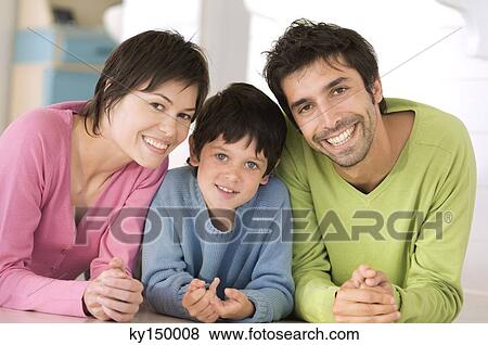 Stock Photo - Parents and son smiling for the camera, lying on floor. Fotosearch