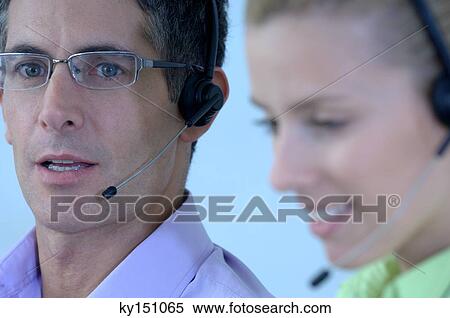 Businessman and businesswoman wearing headset, close-up View Large Photo Image Stock Photography - Businessman and businesswoman wearing headset, close-up. Fotosearch