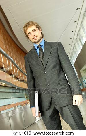 Businessman holding files, low angle view View Large Photo Image Stock Photo - Businessman holding files, low angle view. Fotosearch