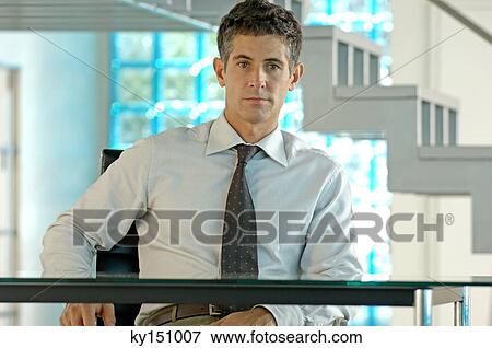 Businessman sitting in office, portrait View Large Photo Image Stock Photo - Businessman sitting in office, portrait. Fotosearch