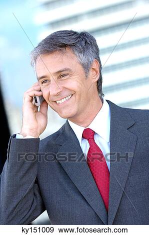 Businessman using mobile phone, smiling View Large Photo Image Stock Photo - Businessman using mobile phone, smiling. Fotosearch