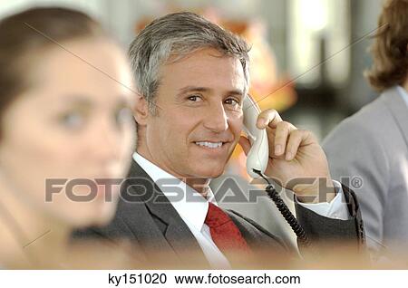 Businessman using telephone, smiling View Large Photo Image Stock Image - Businessman using telephone, smiling. Fotosearch