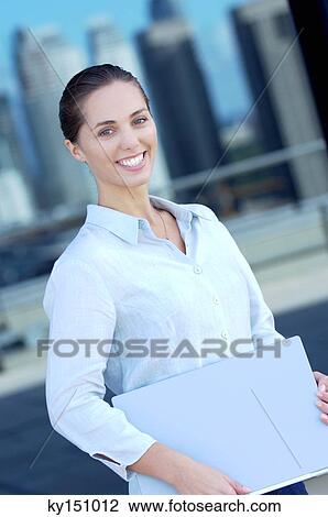 Businesswoman holding files, smiling, side view View Large Photo Image Stock Image - Businesswoman holding files, smiling, side view. Fotosearch