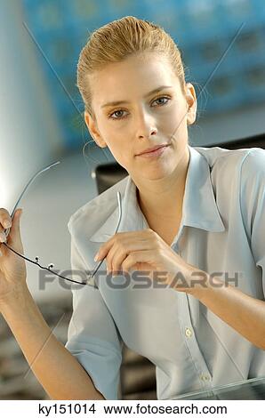 Businesswoman holding glasses, portrait View Large Photo Image Picture - Businesswoman holding glasses, portrait. Fotosearch