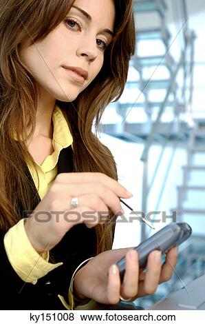 Businesswoman operating mobile phone with stylus View Large Photo Image Stock Photo - Businesswoman operating mobile phone with stylus. Fotosearch