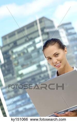 Stock Photograph - Businesswoman using laptop, smiling. Fotosearch