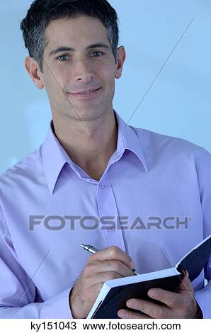 Mid adult businessman holding notebook and pen, portrait View Large Photo Image Stock Image - Mid adult businessman holding notebook and pen, portrait. Fotosearch