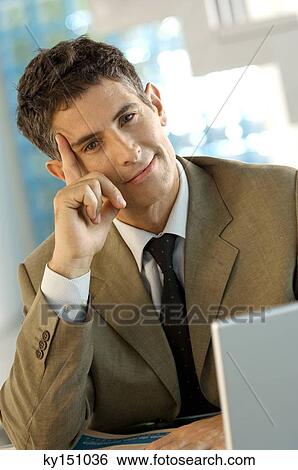 Mid adult businessman sitting in office, portrait View Large Photo Image Stock Photograph - Mid adult businessman sitting in office, portrait. Fotosearch