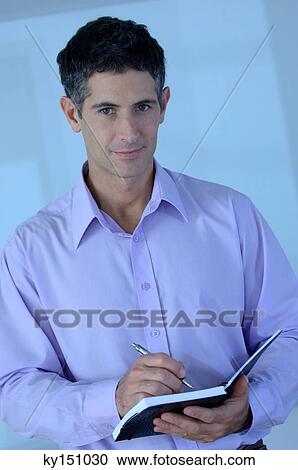 Mid adult man holding notebook and pen, portrait View Large Photo Image Stock Image - Mid adult man holding notebook and pen, portrait. Fotosearch