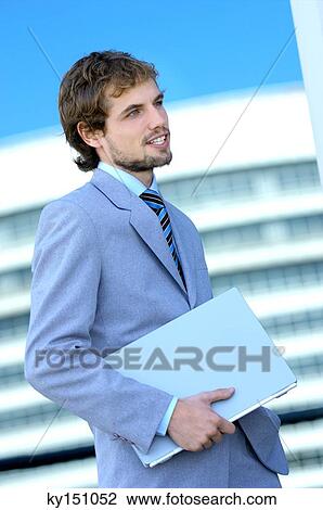 Young businessman holding file, side view View Large Photo Image Stock Image - Young businessman holding file, side view. Fotosearch