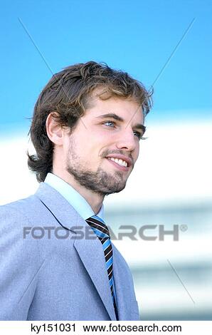 Young businessman smiling, side view View Large Photo Image Stock Image - Young businessman smiling, side view. Fotosearch