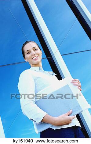 Young businesswoman holding file, low angle view View Large Photo Image Stock Image - Young businesswoman holding file, low angle view. Fotosearch
