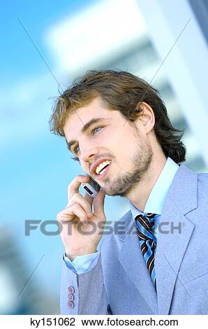Young man using mobile phone View Large Photo Image Stock Image - Young man using mobile phone. Fotosearch