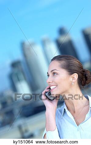 Young woman using mobile phone, smiling View Large Photo Image Picture - Young woman using mobile phone, smiling. Fotosearch