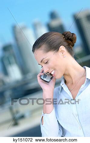 Young woman using mobile phone, smiling View Large Photo Image Stock Image - Young woman using mobile phone, smiling. Fotosearch