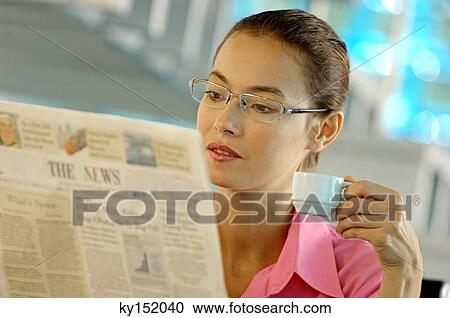 Businesswoman holding cup and reading newspaper View Large Photo Image Stock Image - Businesswoman holding cup and reading newspaper. Fotosearch