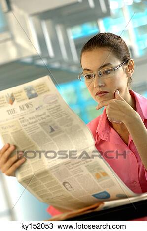 Businesswoman reading newspaper in office View Large Photo Image Stock Image - Businesswoman reading newspaper in office. Fotosearch