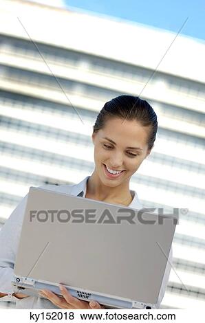 Businesswoman using laptop, smiling View Large Photo Image Stock Photo - Businesswoman using laptop, smiling. Fotosearch