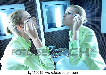 Young businesswoman applying mascara View Large Photo Image Stock Photo - Young businesswoman applying mascara. Fotosearch