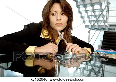 Stock Photograph - Young businesswoman holding pens. Fotosearch