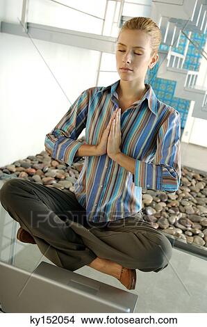 Young businesswoman meditating on glass table View Large Photo Image Picture - Young businesswoman meditating on glass table. Fotosearch
