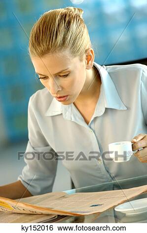Young businesswoman reading newspaper View Large Photo Image Stock Photograph - Young businesswoman reading newspaper. Fotosearch