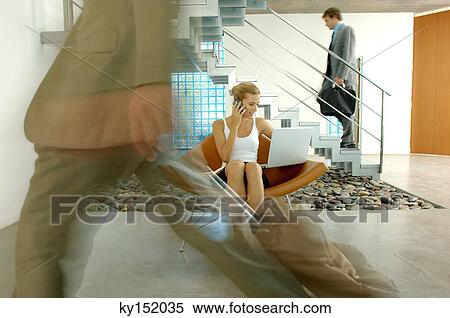 Young businesswoman sitting on chair with laptop and mobile phone in lobby View Large Photo Image Stock Photography - Young businesswoman sitting on chair with laptop and mobile phone in lobby. Fotosearch