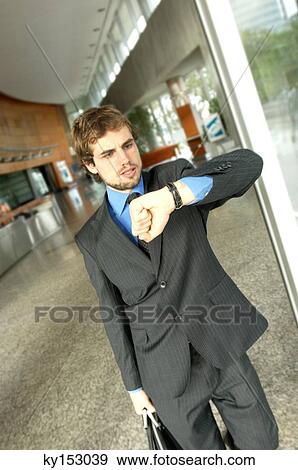 Businessman looking at wristwatch View Large Photo Image Stock Photo - Businessman looking at wristwatch. Fotosearch