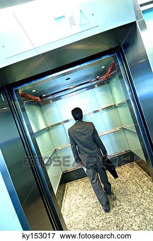 Businessman standing in elevator, rear view View Large Photo Image Stock Photo - Businessman standing in elevator, rear view. Fotosearch