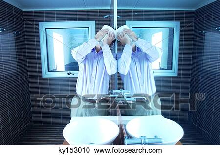 Man covering face with handkerchief while leaning by mirror in washroom View Large Photo Image Stock Image - Man covering face with handkerchief while leaning by mirror in washroom. Fotosearch