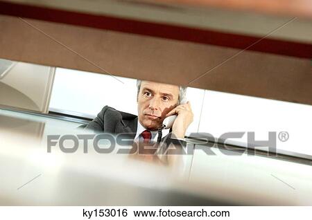 Mature businessman holding telephone receiver View Large Photo Image Stock Photograph - Mature businessman holding telephone receiver. Fotosearch