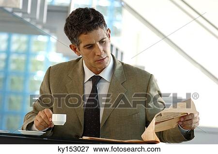 Mid adult businessman reading newspaper View Large Photo Image Stock Photo - Mid adult businessman reading newspaper. Fotosearch