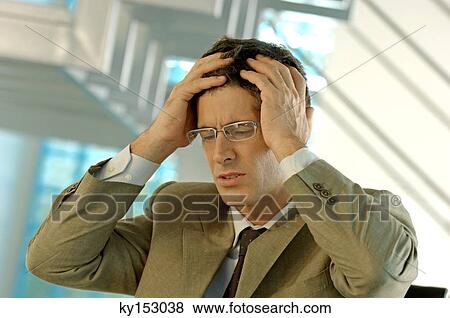 Stock Photo - Mid adult businessman with hands on head. Fotosearch