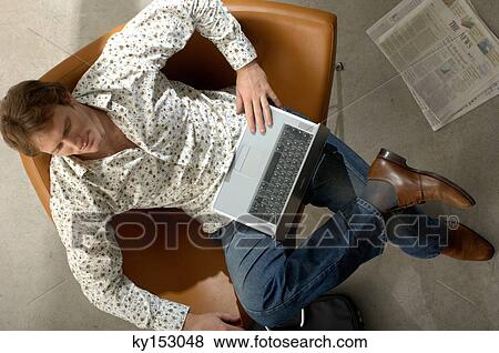 Young man using laptop, overhead view View Large Photo Image Stock Photo - Young man using laptop, overhead view. Fotosearch