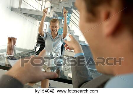 Businessman pointing with young woman smiling in background View Large Photo Image Stock Image - Businessman pointing with young woman smiling in background. Fotosearch