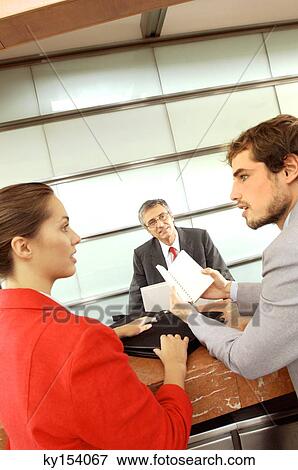 Stock Photo - Businessmen and businesswoman conversing in office. Fotosearch