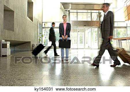 Businessmen with businesswoman walking in lobby low angle view View Large Photo Image Stock Image - Businessmen with businesswoman walking in lobby low angle view. Fotosearch