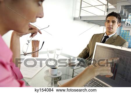 Picture - Businesswoman conversing with businessman in office. Fotosearch