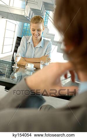 Businesswoman smiling by desk in office View Large Photo Image Picture - Businesswoman smiling by desk in office. Fotosearch