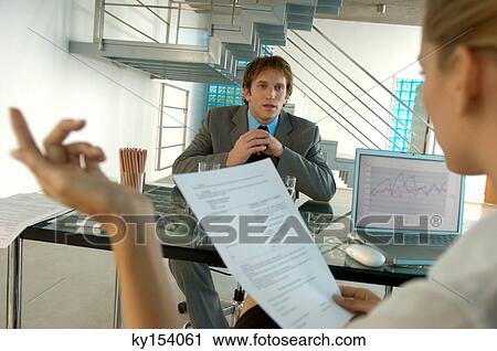 Stock Image - Businesswoman taking interview of young man. Fotosearch