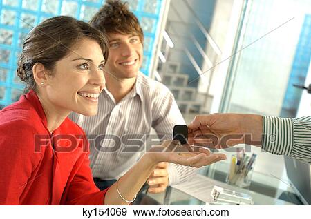 Car dealer handing car key to customer, smiling View Large Photo Image Stock Photo - Car dealer handing car key to customer, smiling. Fotosearch