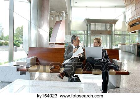 Stock Image - Two businessmen discussing with each other. Fotosearch