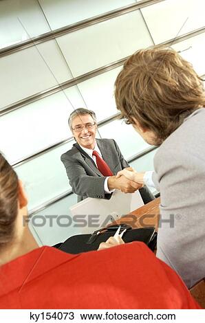 Two businessmen shaking hands in office View Large Photo Image Stock Image - Two businessmen shaking hands in office. Fotosearch