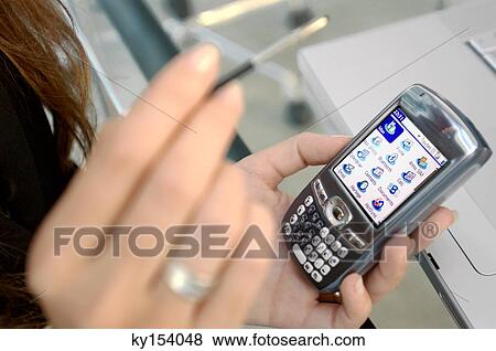 Woman holding mobile phone and stylus, close-up View Large Photo Image Stock Photo - Woman holding mobile phone and stylus, close-up. Fotosearch