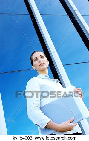 Young businesswoman holding file, low angle view View Large Photo Image Stock Image - Young businesswoman holding file, low angle view. Fotosearch