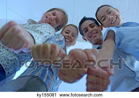 Stock Image - Business colleagues with clenched fist, portrait, low angle view. Fotosearch