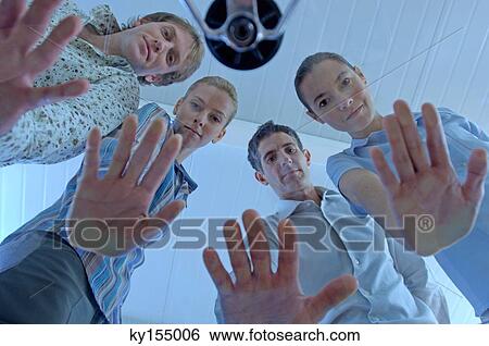 Stock Photograph - Business people showing hands, low angle view. Fotosearch
