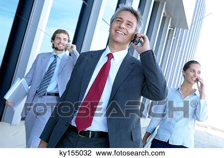 Stock Image - Business people using mobile phone. Fotosearch
