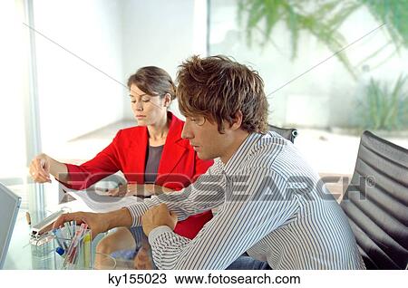 Businessman and businesswoman sitting in office View Large Photo Image Stock Image - Businessman and businesswoman sitting in office. Fotosearch